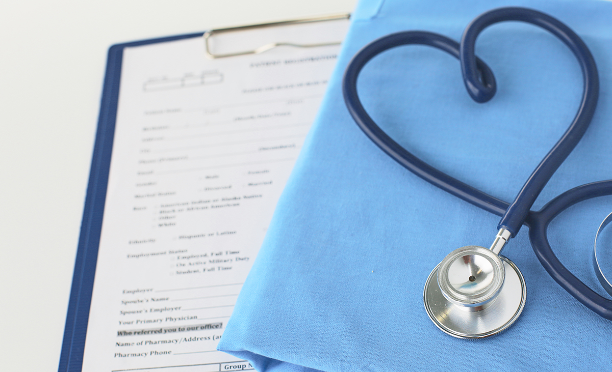 A stethoscope shaping a heart on a medical uniform, closeup, selective focus